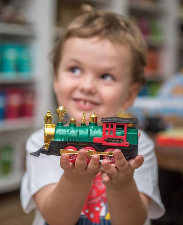 Child holding train model.
