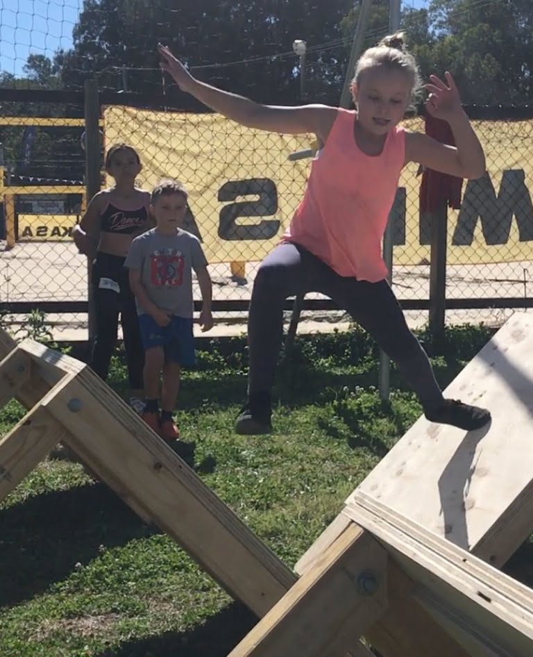 Girl taking on the ninja style obstacles