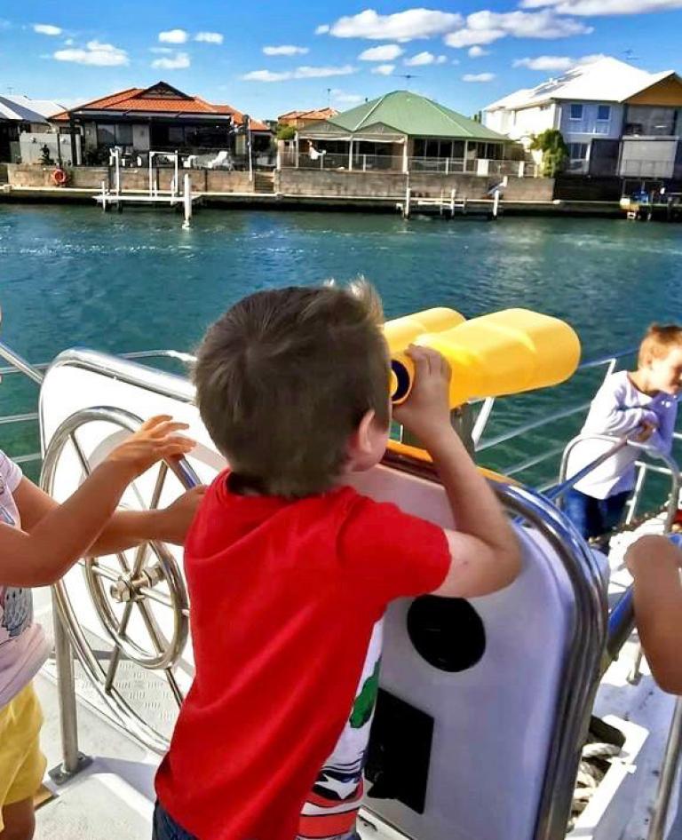 Kids looking out from the boat during Mandurah cruise.