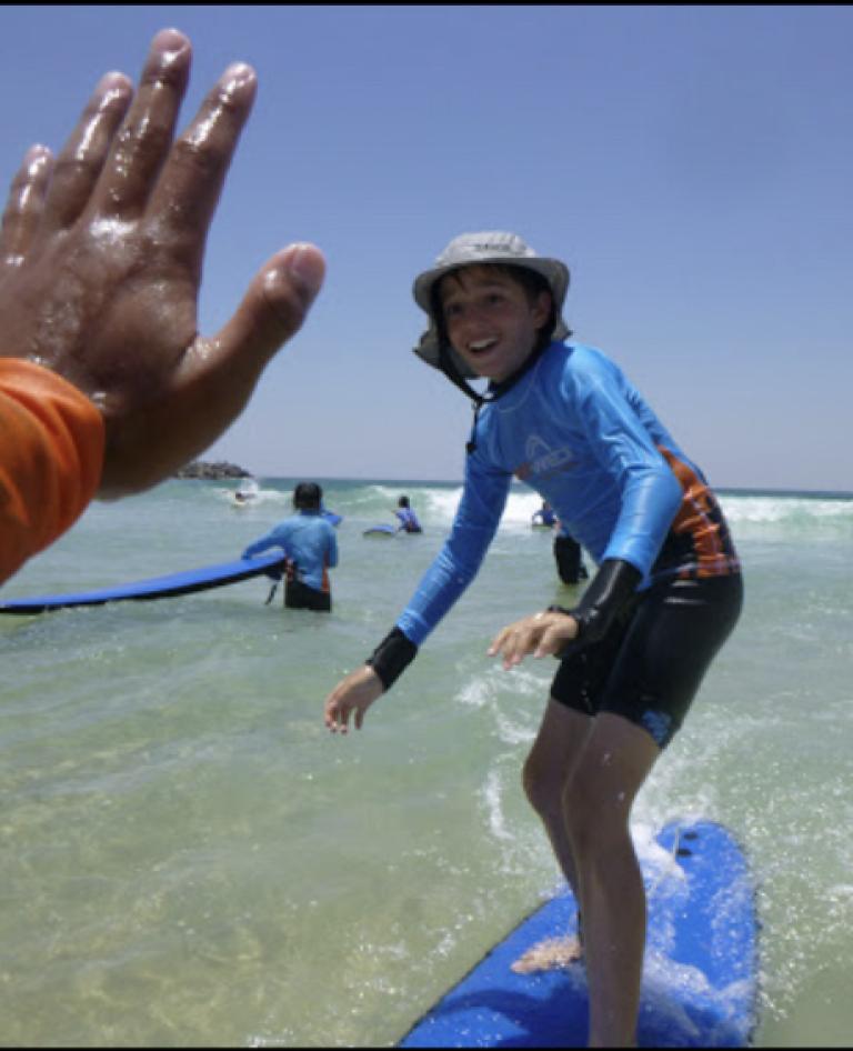 Child enjoying learn to surf on the Gold Coast.