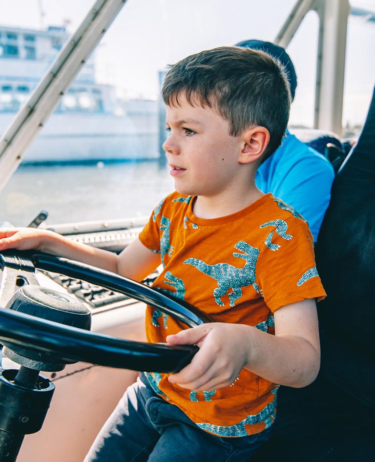 Boy feeling a sense of pride and freedom as he plays skipper on Aquaduck