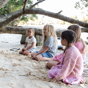 Young children sitting on Echo Beach at Burleigh Heads listening to stories of Jellurgal