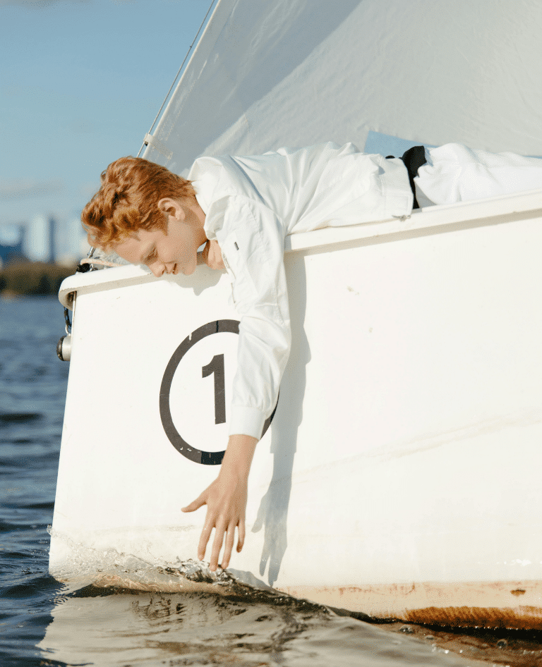 Teen reaching for the water on Sydney Harbour